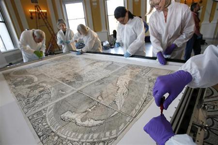 Conservators at the Library of Congress prepare a map for its encasement in Washington