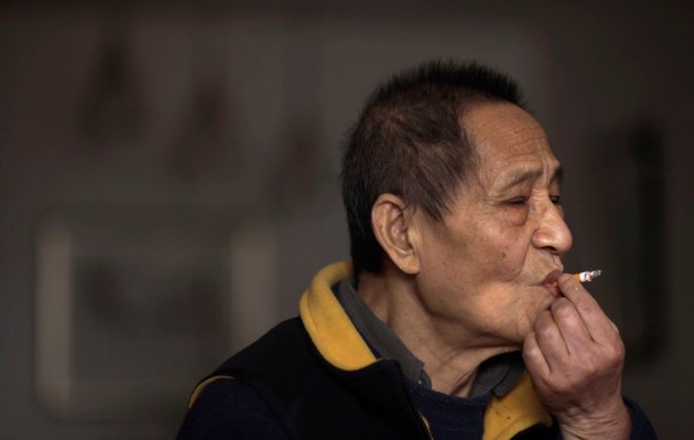 File photo of Bao, a former member of the Central Committee of the Communist Party of China, smoking at home during an interview in Beijing
