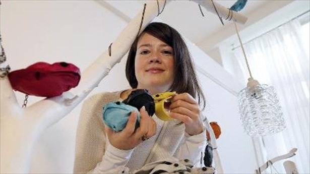 Polish-designer-Monika-Jarosz-poses-with-products-made-with-Australian-cane-toads-on-Oct.-9-2013-in-Paris.-AFP
