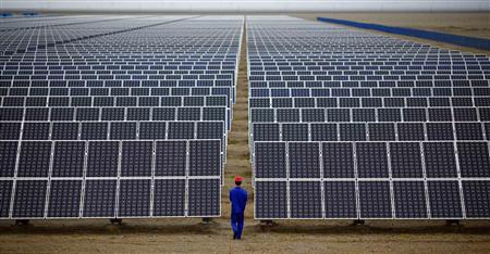 File photo of worker inspecting solar panels at a solar farm in Dunhuang